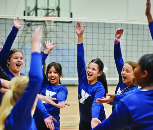 Youth Volleyball Team Huddled in Celebration