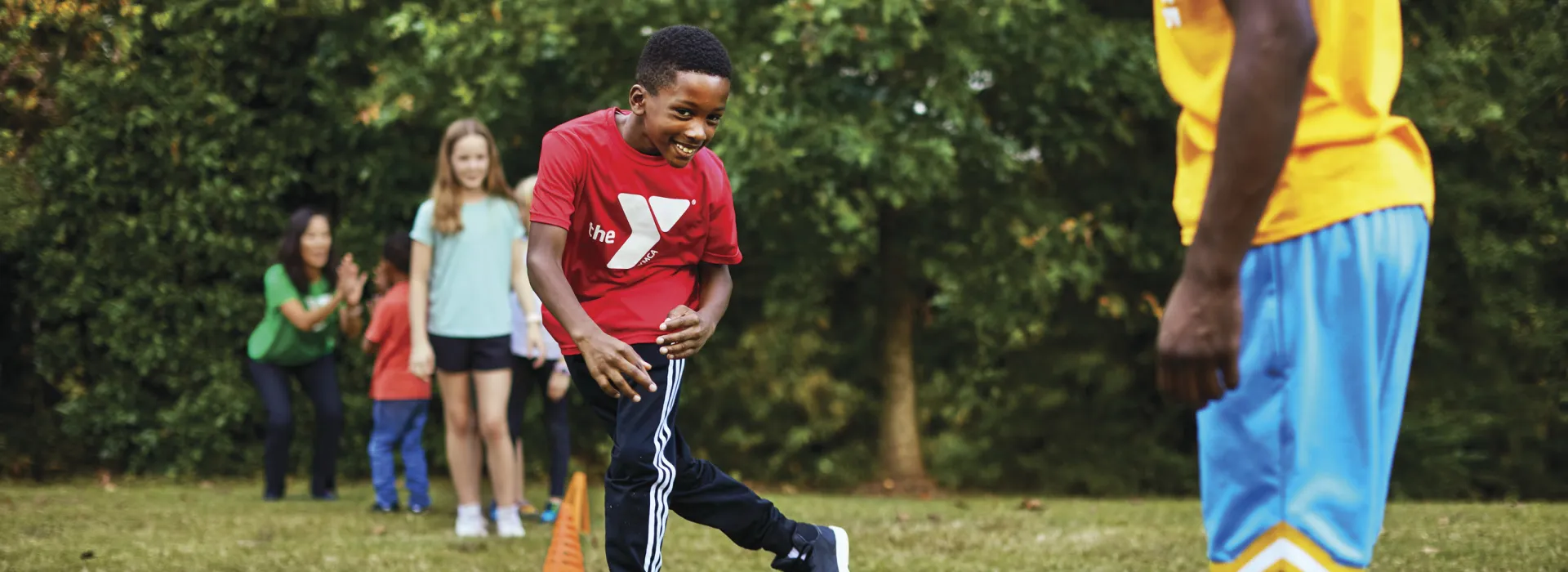 Young children line up outside to complete an obstacle course that was set up by Y staff members.