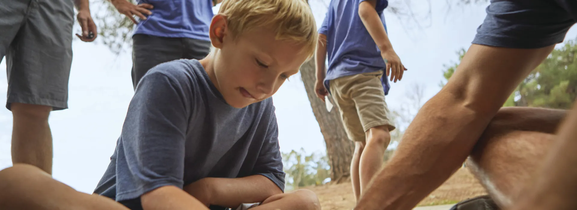 Torrance-South Bay YMCA's Voyager Adventure Guides Fall-Campout. Youth coloring with an adult counselor while sitting on the ground.